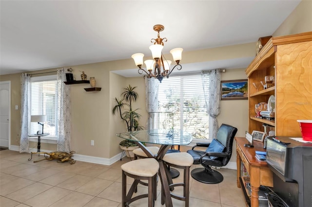 dining space featuring a healthy amount of sunlight, light tile patterned floors, and an inviting chandelier