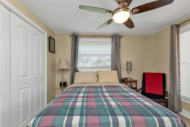 bedroom featuring multiple windows, ceiling fan, and a closet