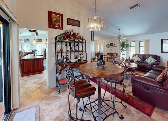 dining space featuring light tile patterned floors and ceiling fan with notable chandelier