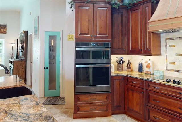 kitchen with custom exhaust hood, sink, black electric cooktop, double oven, and tasteful backsplash