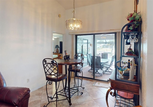 dining space with a chandelier, light tile patterned floors, and high vaulted ceiling