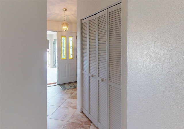 foyer featuring light tile patterned floors and a notable chandelier