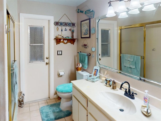 bathroom with tile patterned floors, a shower with door, vanity, and toilet