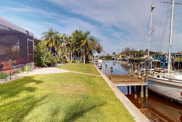 view of dock with a lawn, a lanai, and a water view