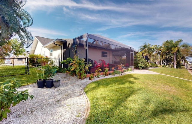 exterior space featuring a yard and glass enclosure