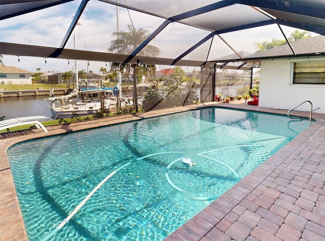 view of pool with a water view and glass enclosure