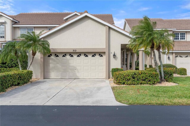 3800 Bal Harbor Blvd Unit 312, Punta Gorda, FL 33950 - view of front of home featuring stucco siding, driveway, an attached garage, and a tiled roof