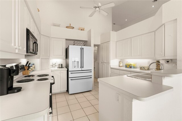 3800 Bal Harbor Blvd Unit 312, Punta Gorda, FL 33950 - kitchen with white fridge with ice dispenser, black microwave, a sink, a towering ceiling, and light tile patterned flooring