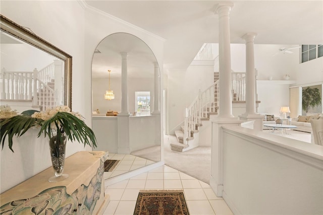 carpeted foyer featuring ceiling fan and ornamental molding