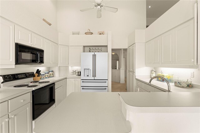 3800 Bal Harbor Blvd Unit 312, Punta Gorda, FL 33950 - kitchen with black microwave, white fridge with ice dispenser, electric range oven, a high ceiling, and white cabinets