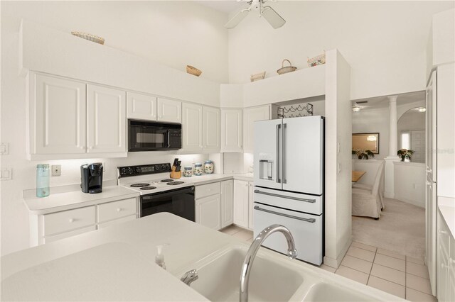 3800 Bal Harbor Blvd Unit 312, Punta Gorda, FL 33950 - kitchen featuring black microwave, range with electric cooktop, white fridge with ice dispenser, white cabinets, and a high ceiling