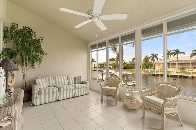 sunroom / solarium with ceiling fan, a water view, and lofted ceiling