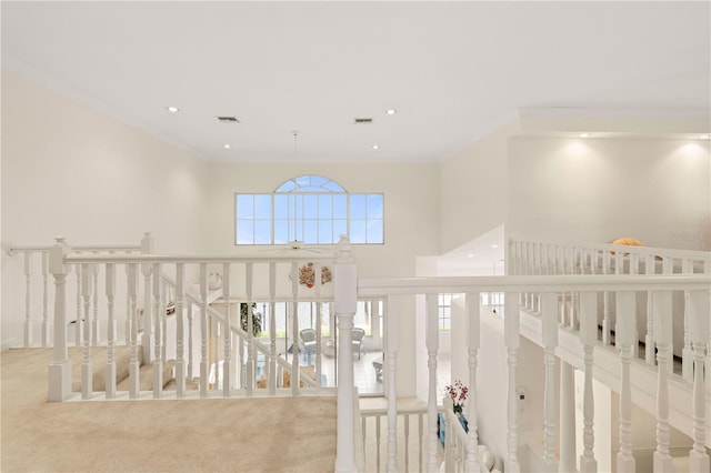 corridor featuring crown molding and light carpet