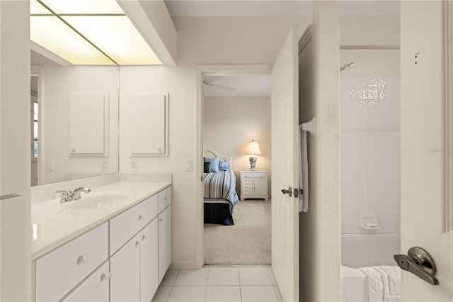 bathroom with tile patterned floors, tiled shower / bath combo, ceiling fan, and vanity