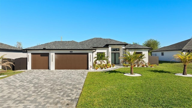 prairie-style house featuring a garage and a front lawn