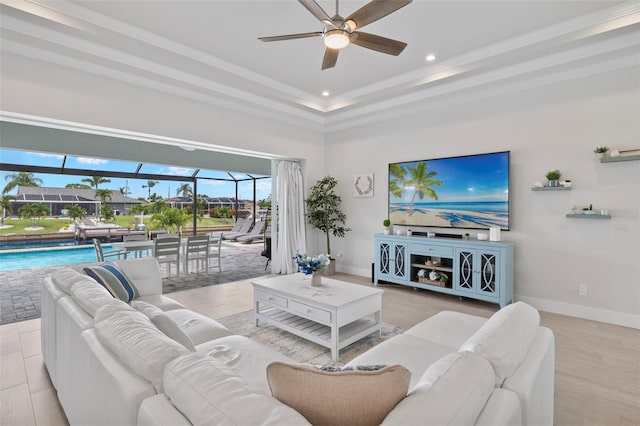 living room featuring light hardwood / wood-style floors, a raised ceiling, and a wealth of natural light