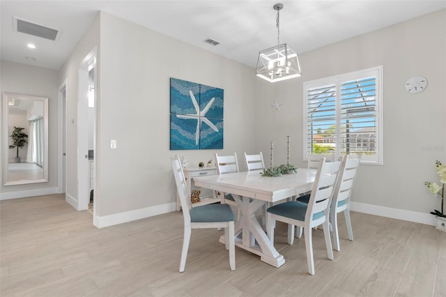 dining area featuring light hardwood / wood-style floors and an inviting chandelier