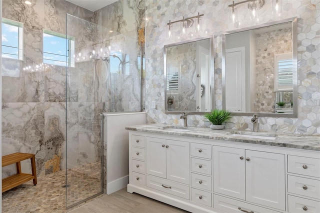 bathroom with a tile shower, vanity, and hardwood / wood-style flooring