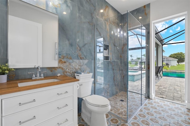 bathroom featuring vanity, toilet, tile walls, and a tile shower