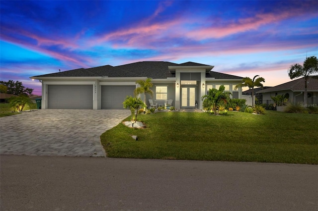 prairie-style home with a garage and a lawn