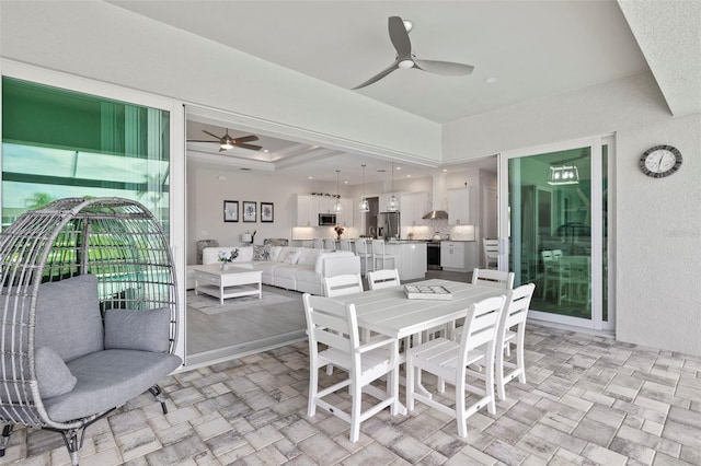 dining room featuring ceiling fan and a raised ceiling