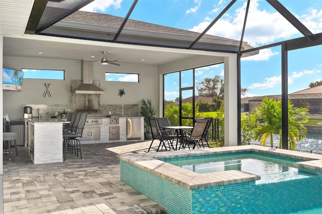 view of pool featuring exterior kitchen, ceiling fan, a lanai, an in ground hot tub, and a bar