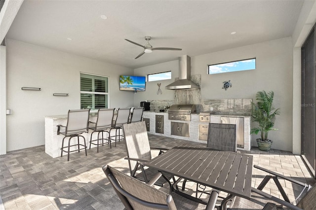 view of patio / terrace with area for grilling, ceiling fan, an outdoor bar, and an outdoor kitchen