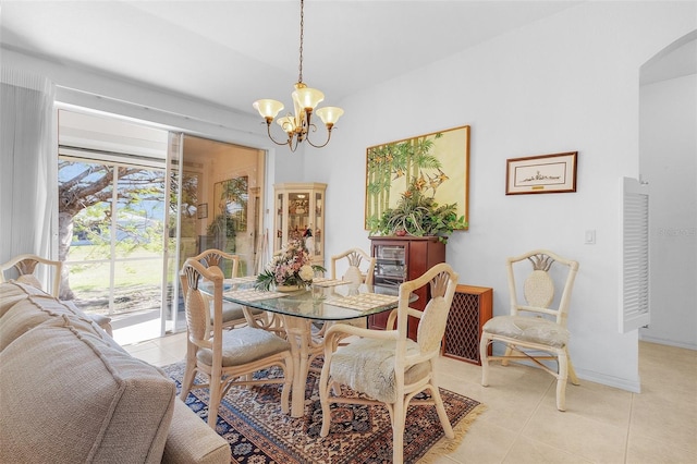 tiled dining room featuring a chandelier