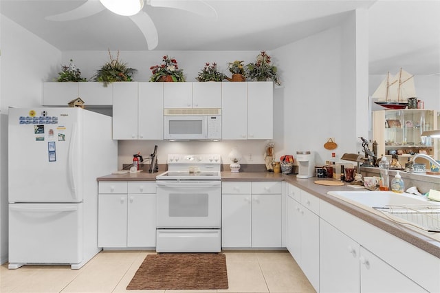 kitchen with white cabinets, white appliances, sink, and light tile patterned floors