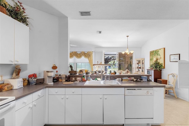 kitchen with white appliances, sink, a chandelier, white cabinetry, and hanging light fixtures