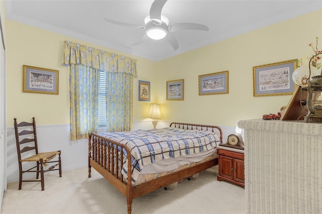 bedroom with ceiling fan, ornamental molding, and light carpet