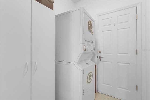 washroom featuring light tile patterned floors and stacked washing maching and dryer