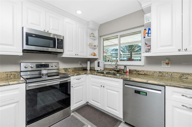 kitchen with dark stone counters, sink, white cabinets, and stainless steel appliances