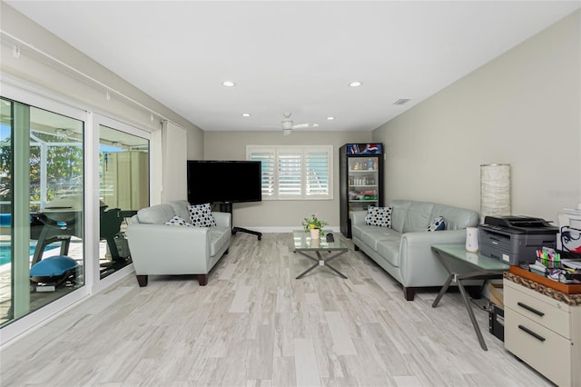 living room with ceiling fan and light wood-type flooring