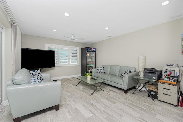 living room featuring ceiling fan and light hardwood / wood-style floors