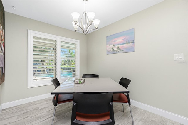 dining area featuring light hardwood / wood-style floors and an inviting chandelier