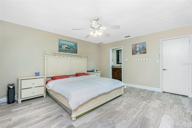 bedroom featuring ceiling fan, light hardwood / wood-style flooring, and ensuite bathroom