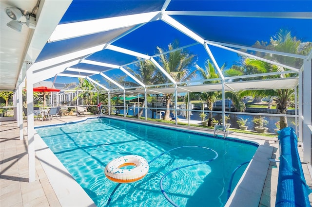 view of pool featuring a lanai, a patio area, and a water view