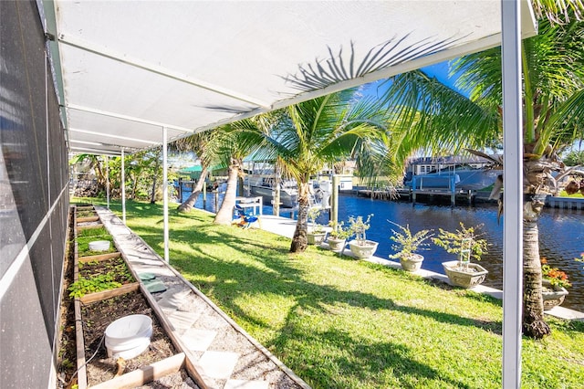 view of yard with a water view and a dock