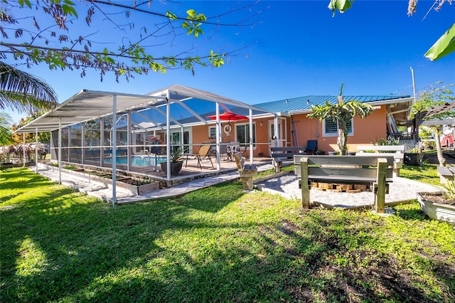 back of house with a lanai, a patio area, and a lawn