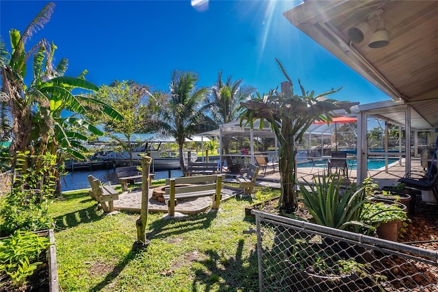 view of yard featuring a dock, a lanai, and a water view