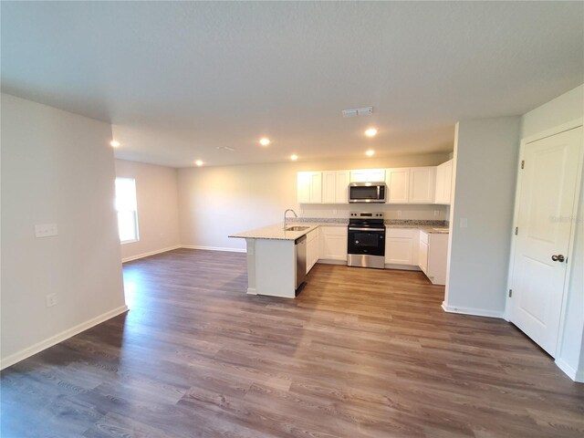kitchen featuring visible vents, dark wood-type flooring, open floor plan, stainless steel appliances, and a peninsula