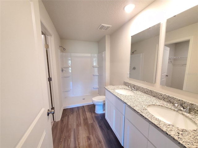 full bathroom with wood finished floors, walk in shower, and a sink