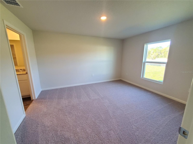 empty room with recessed lighting, carpet flooring, baseboards, and visible vents