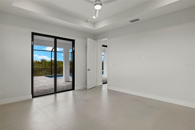 empty room with a tray ceiling and ceiling fan