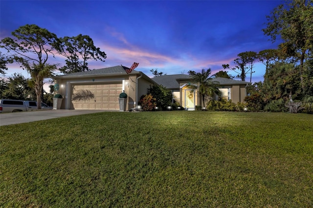 single story home featuring a garage and a yard