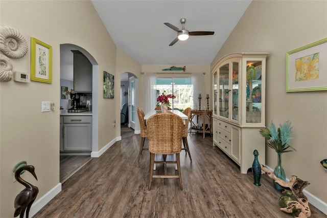 dining room featuring ceiling fan, dark wood-type flooring, and vaulted ceiling