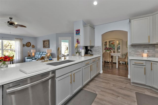 kitchen with ceiling fan, sink, tasteful backsplash, stainless steel dishwasher, and light hardwood / wood-style floors