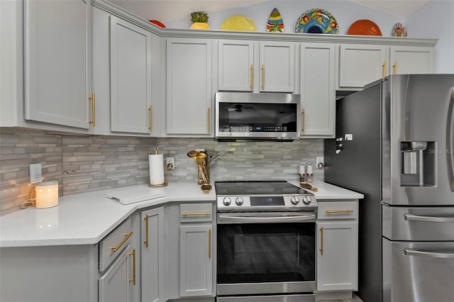 kitchen featuring gray cabinetry, stainless steel appliances, and tasteful backsplash