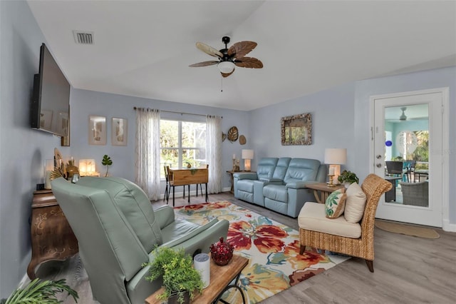 living room with ceiling fan, light wood-type flooring, and lofted ceiling